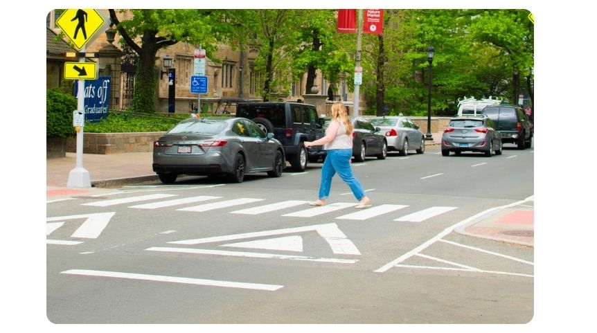 Lady walking across a New Haven crosswalk